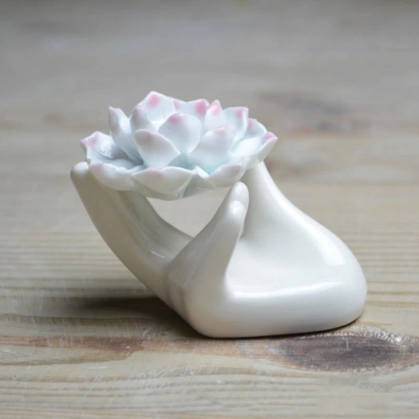 Right three-quarter view of glossy ceramic lotus incense burner displaying smooth hand base and pastel pink-white lotus petals