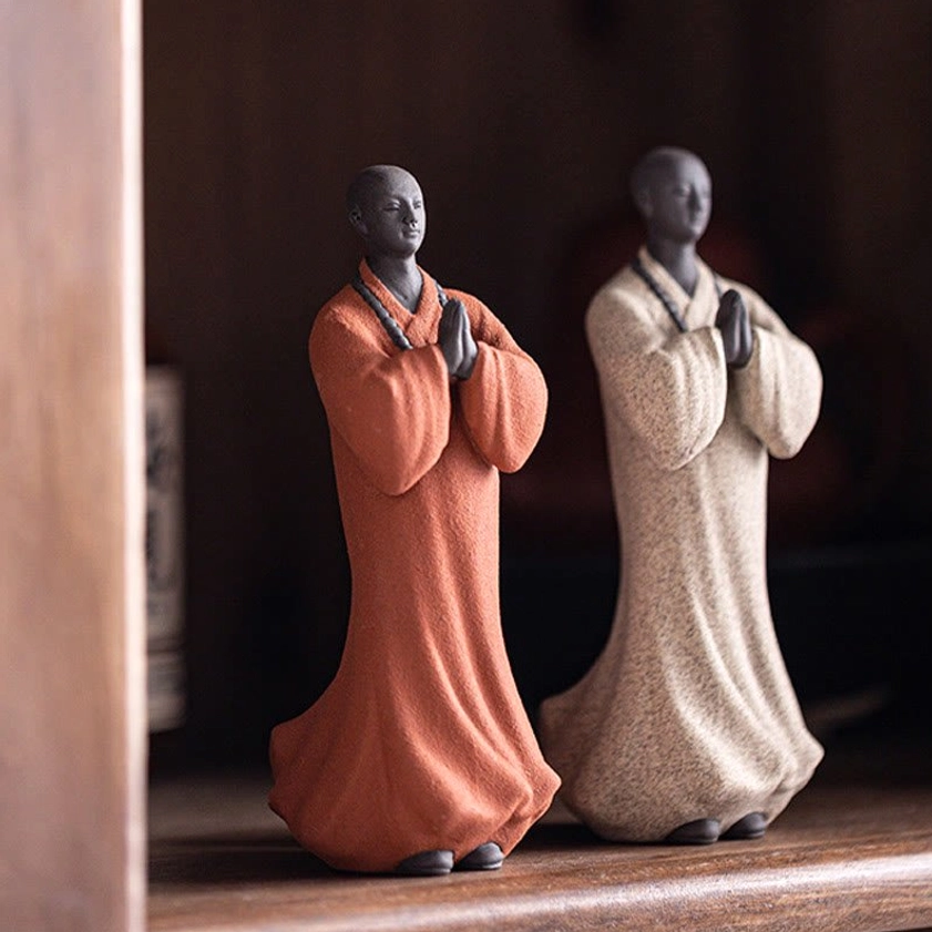 Detailed close-up of handcrafted ceramic meditation monk figurine showing prayer bead necklace and facial features