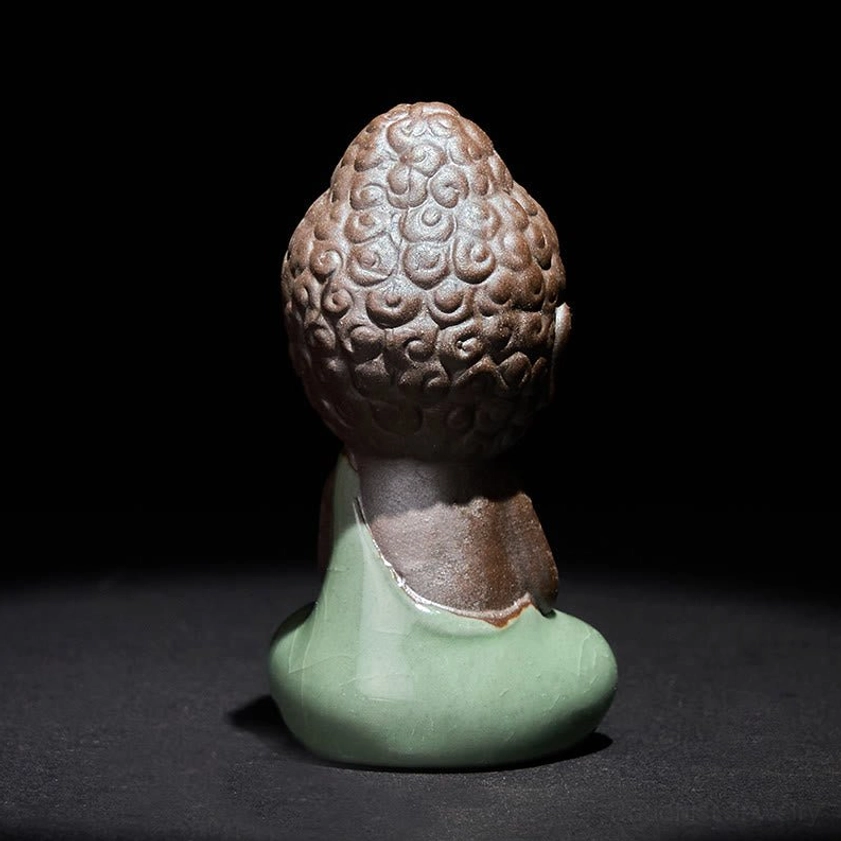 Rear view of handcrafted ceramic meditation monk statue showing back and flowing robe