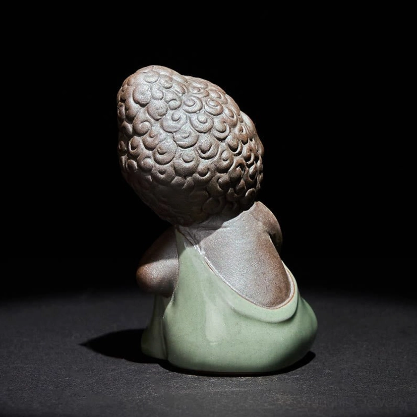 Ceramic meditation monk figure featuring curly Buddha hair and contemplative pose