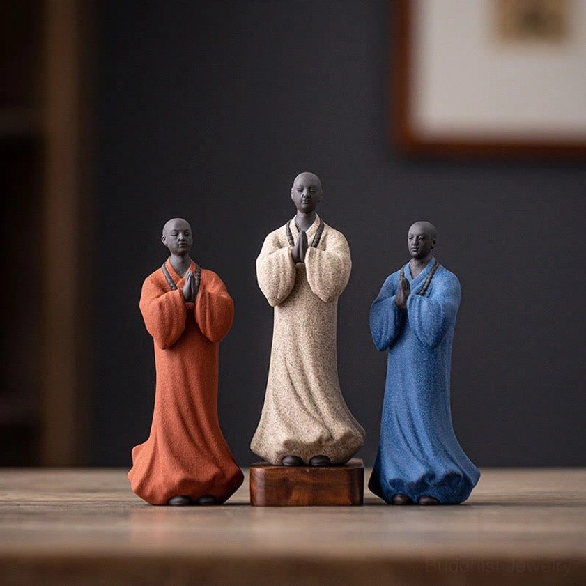 Handcrafted ceramic monk figurine with matte finish shown at eye level on wooden surface with home decor background