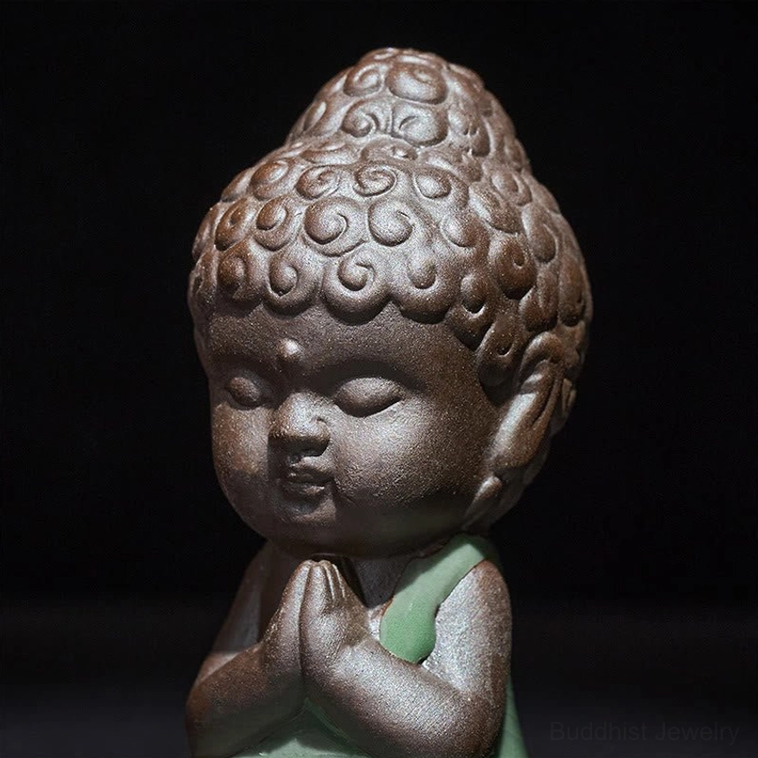 Close-up detail of ceramic meditation monk face with peaceful expression and textured hair