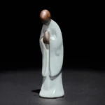 Handcrafted ceramic meditation monk statue with pale cyan glaze, front left perspective view