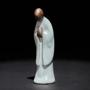 Handcrafted ceramic meditation monk statue with pale cyan glaze, front left perspective view