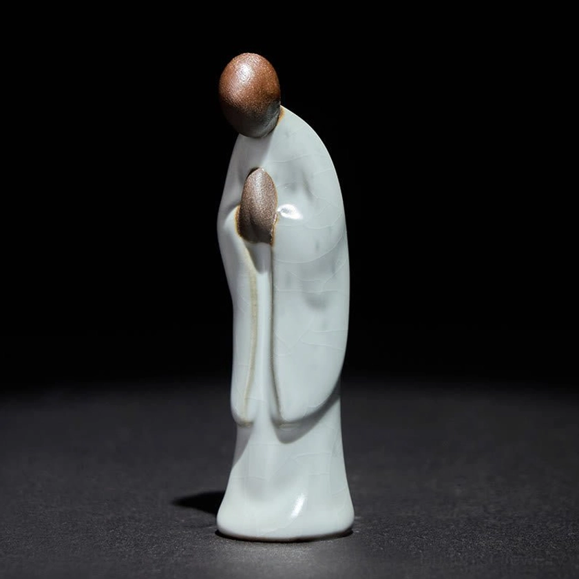 Handcrafted ceramic meditation monk statue with pale cyan glaze, front left perspective view