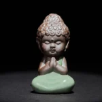Handcrafted ceramic meditation monk statue in prayer pose with curly Buddha hair and folded hands