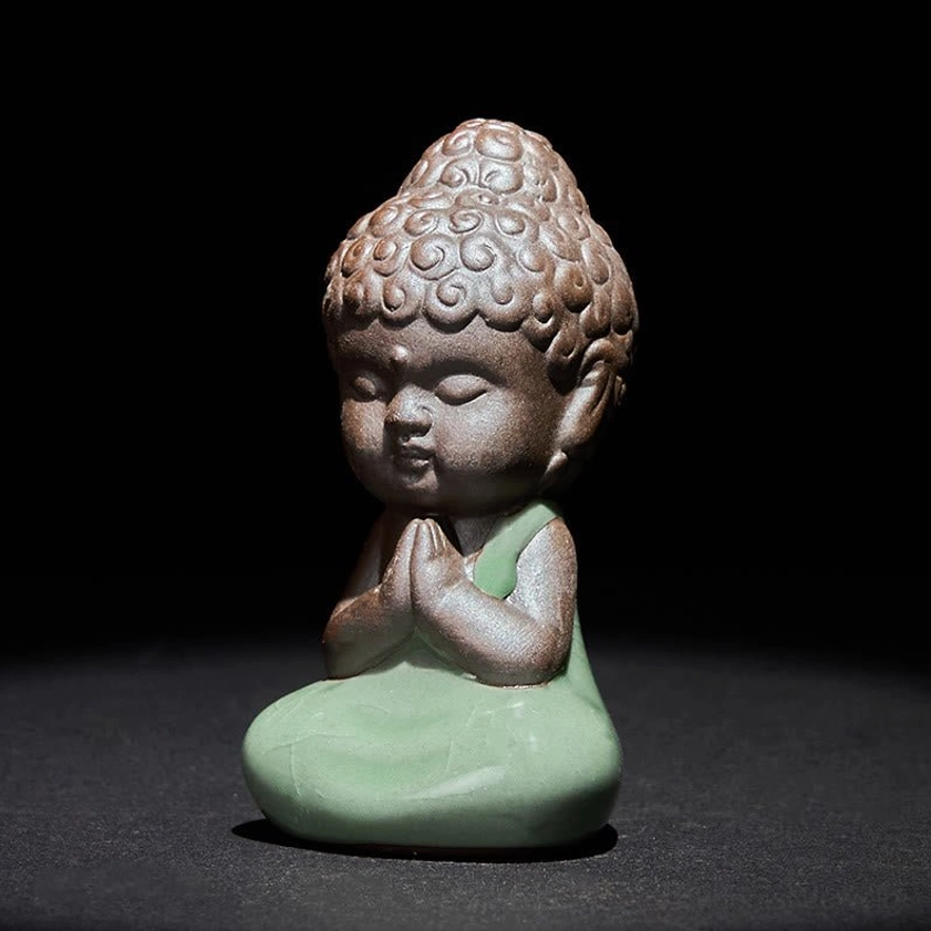 Buddhist ceramic monk statue in seated cross-legged meditation position viewed from front angle