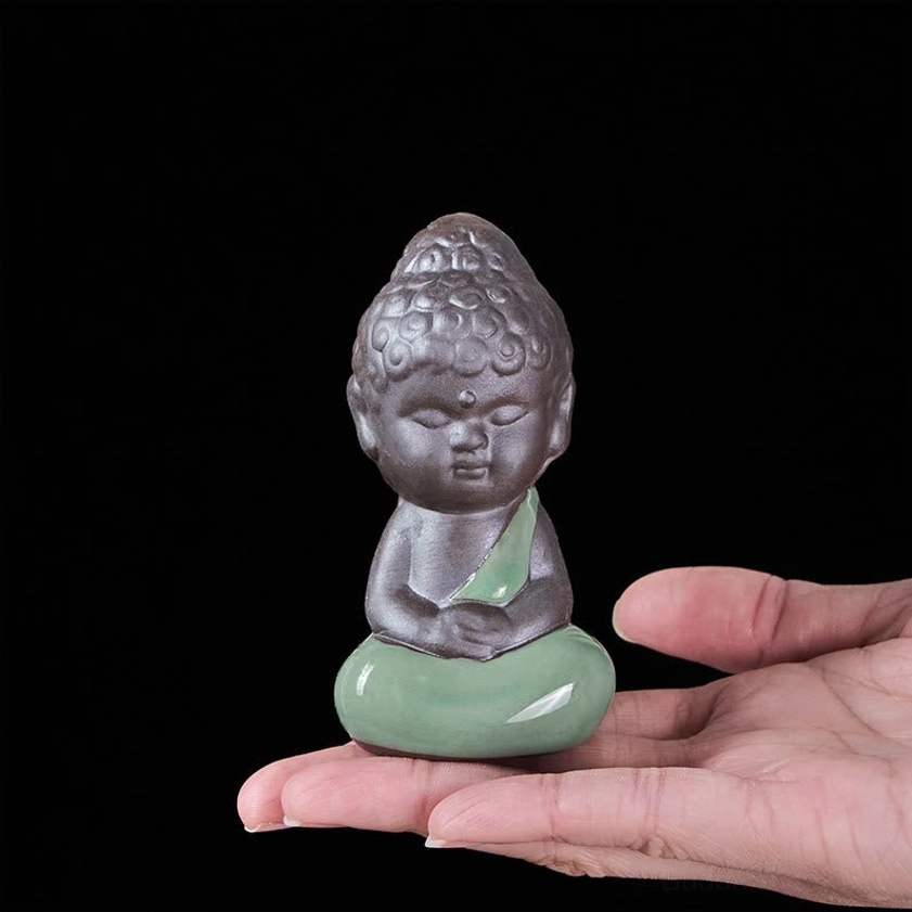 Ceramic meditation monk statue displayed on black background studio photography