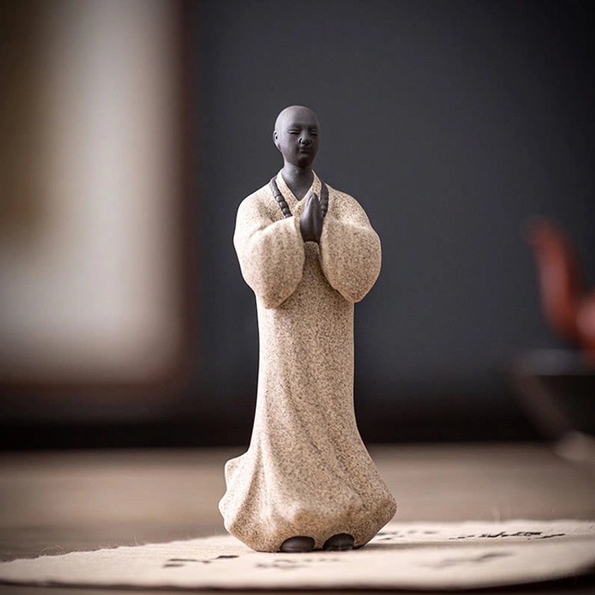 Three ceramic meditation monk statues in different colors showcasing collection of Buddhist spiritual figurines