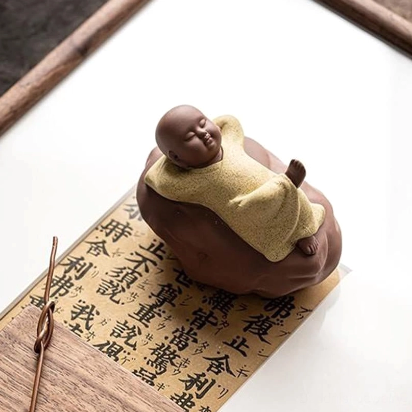 Handcrafted ceramic monk figurine detail shot highlighting fine artisan carving and glaze work