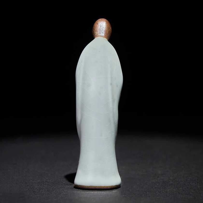 Back view of handcrafted ceramic monk statue showing robe texture and design details