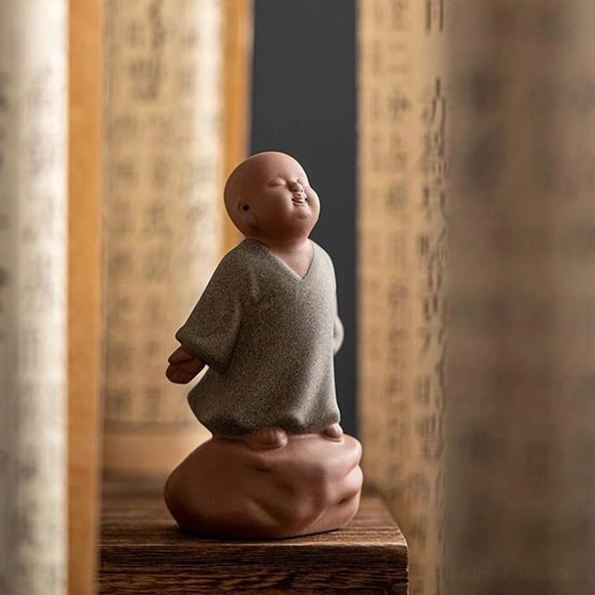 Handcrafted ceramic monk statue rear side view on antique scroll shelf display