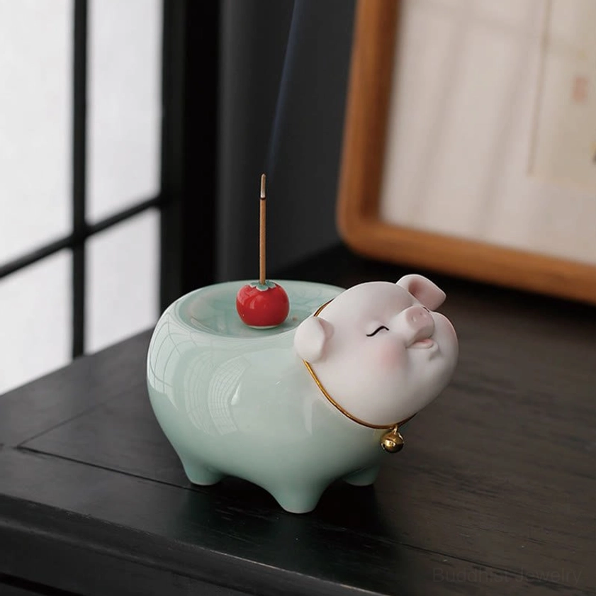 Side profile of ceramic pig incense burner with incense smoke rising, celadon finish against window backdrop