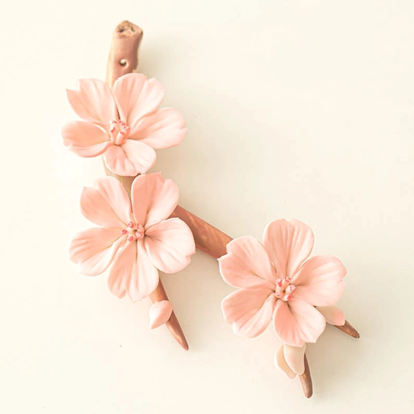 Handcrafted ceramic plum blossom incense holder with lifelike 3D pink flowers and wood-textured base, flat lay top-down view