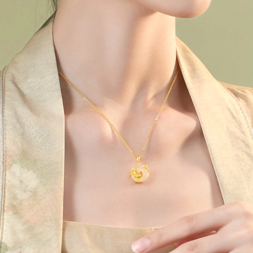 Model wearing white chalcedony lotus peace buckle necklace positioned at collarbone with traditional backdrop