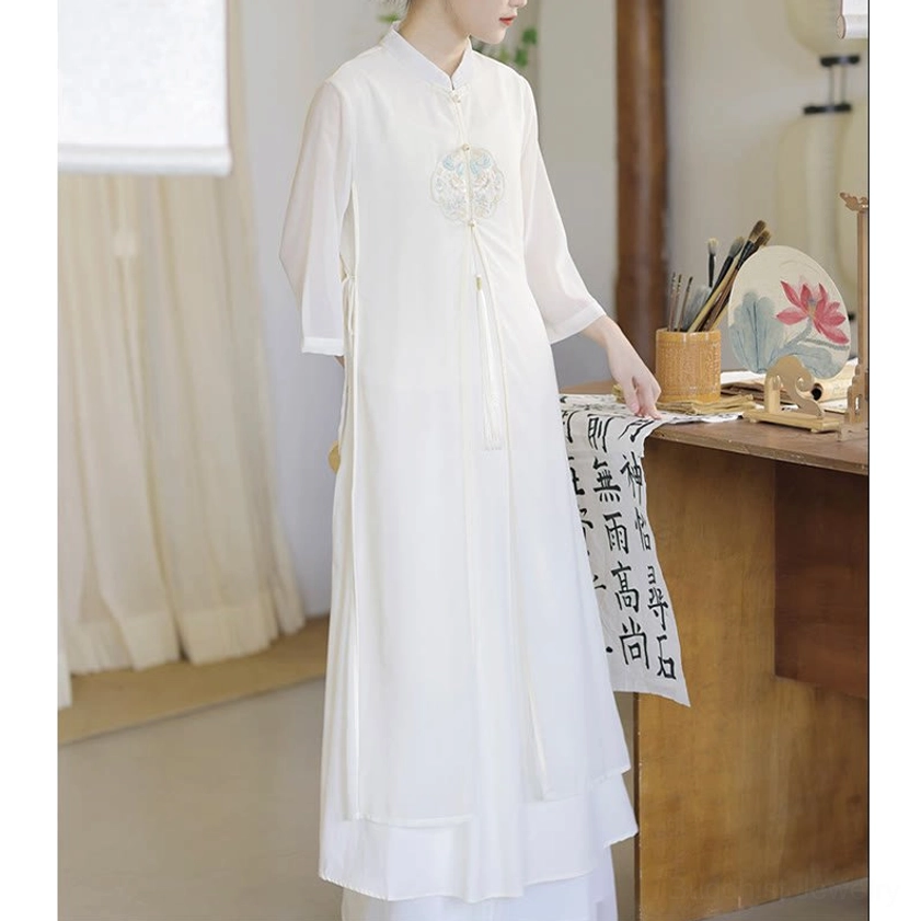 Cheongsam-style long meditation dress in off-white with side slit and tassel waist detail, right side view showcasing flowing fabric and elegant cut