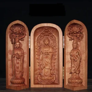 Front view of tri-fold cherry wood Buddhist altar shrine with gilded hinges displaying three carved Buddha statues on dark wood table