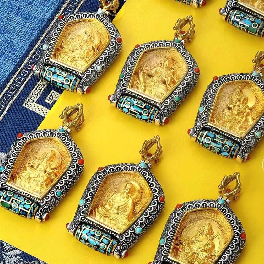 Multiple zodiac Natal Buddha pendants collection flat lay showing 12 Buddhist deity styles with silver frames and gemstone details