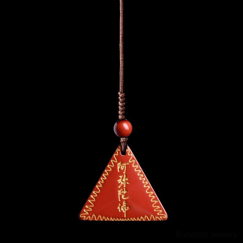 Purple-red cinnabar Amitabha pendant with thin brown braided rope and spacer bead on dark red background