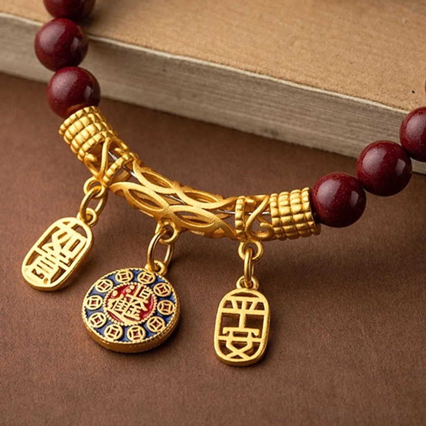Handmade cinnabar blessing charm with white jade accents and intricate gold filigree details, authentic Buddhist spiritual talisman for peace