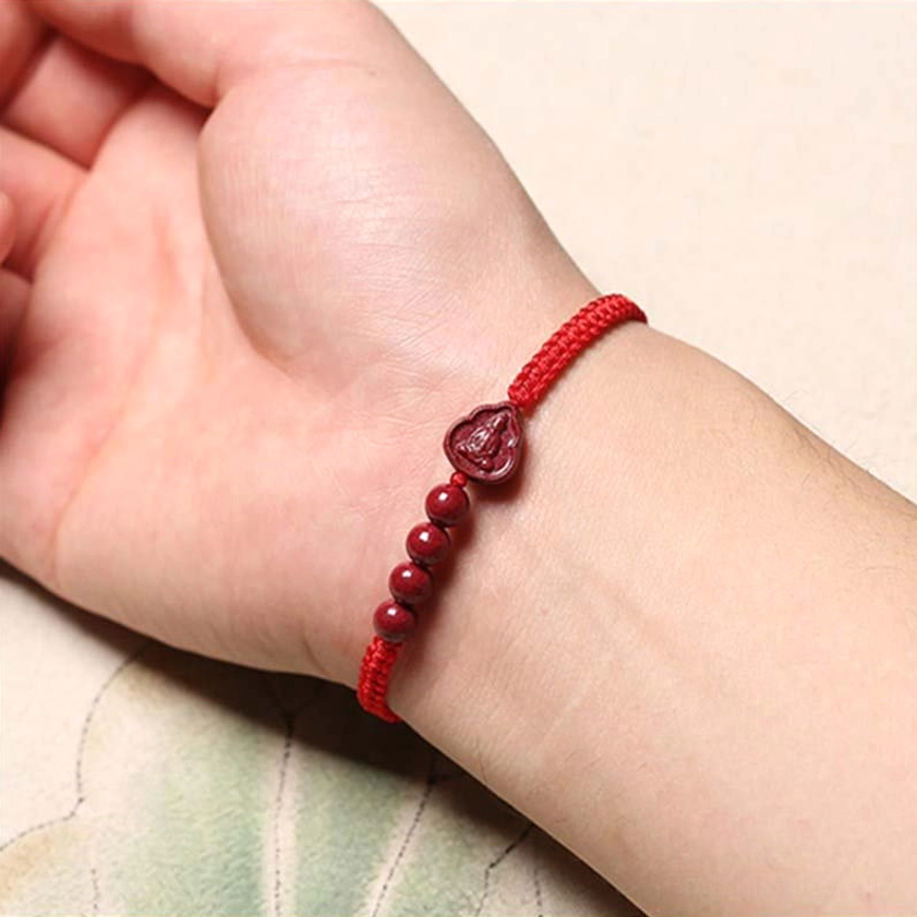 Red cinnabar Buddha bracelet worn on wrist, close-up shot showing comfortable fit and spiritual elegance