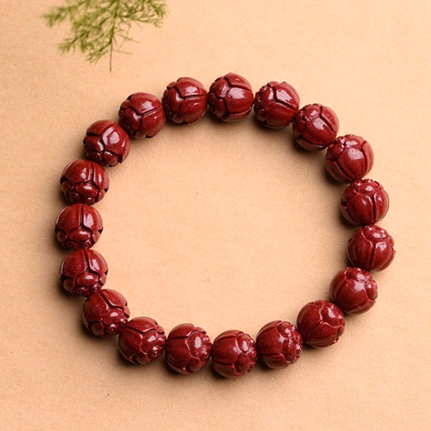 Buddhist cinnabar bracelet collection overview showing multiple carved styles: Om Mani Padme Hum, lotus, and fret patterns
