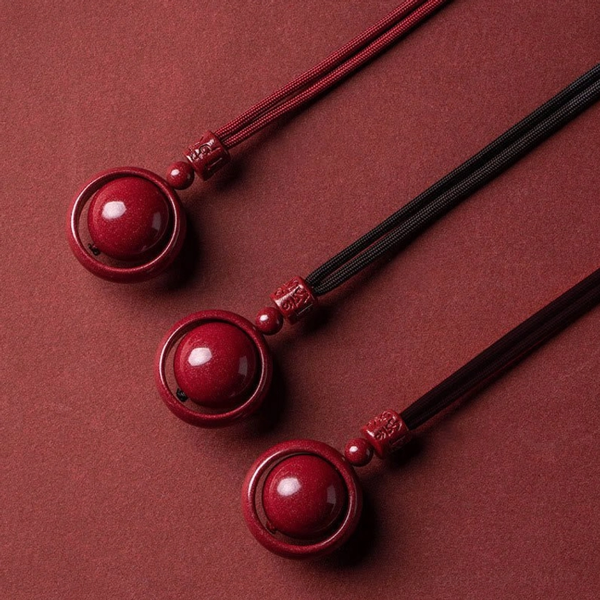 Three-piece cinnabar buddhist necklace pendants set with mixed red and black cords, flat lay display