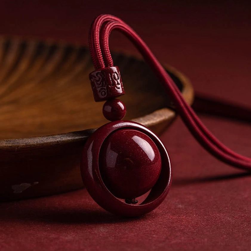 Buddhist cinnabar pendant necklace showing natural speckled texture and rich red color