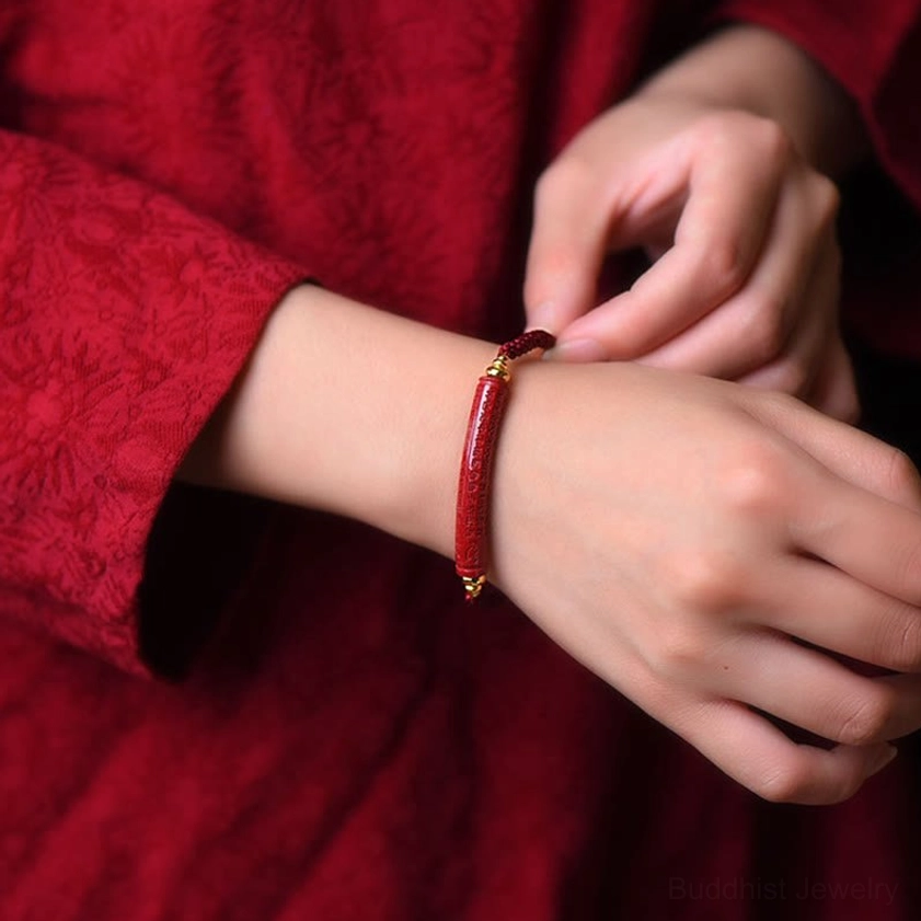 Buddhist red string cinnabar blessing bracelet worn on wrist, lifestyle close-up with gold metal beads