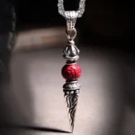 Cinnabar Dorje Vajra Buddhist pendant necklace front close-up showing engraved spike design and red cinnabar bead