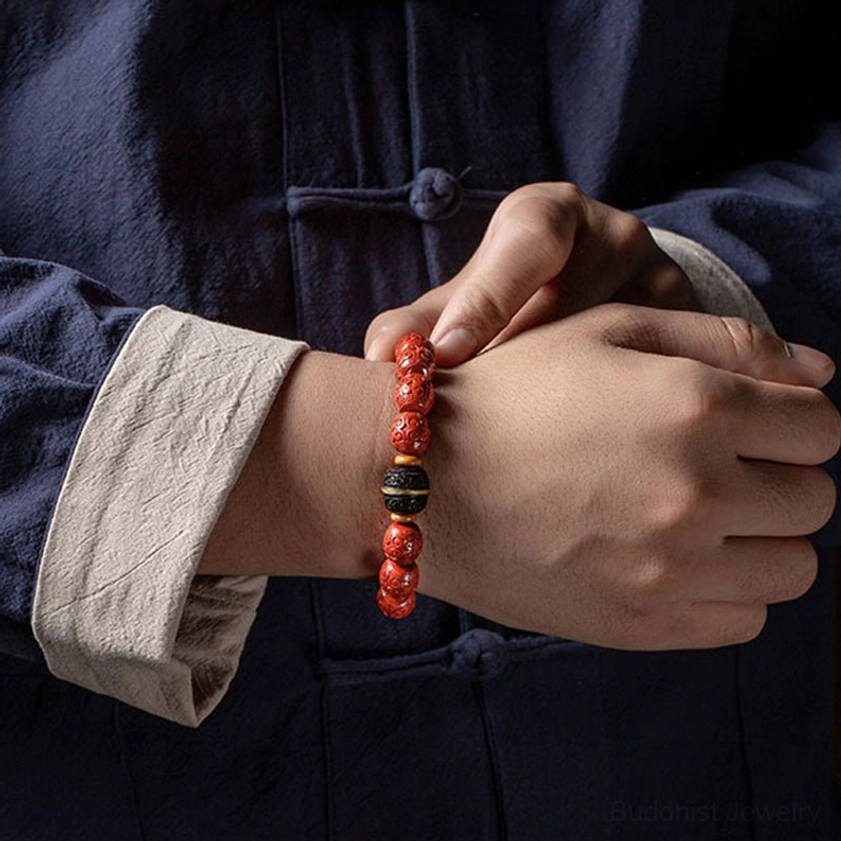 Buddhist cinnabar and ebony blessing bracelet worn on both wrists with traditional Han clothing background, front two-hand perspective showing full design
