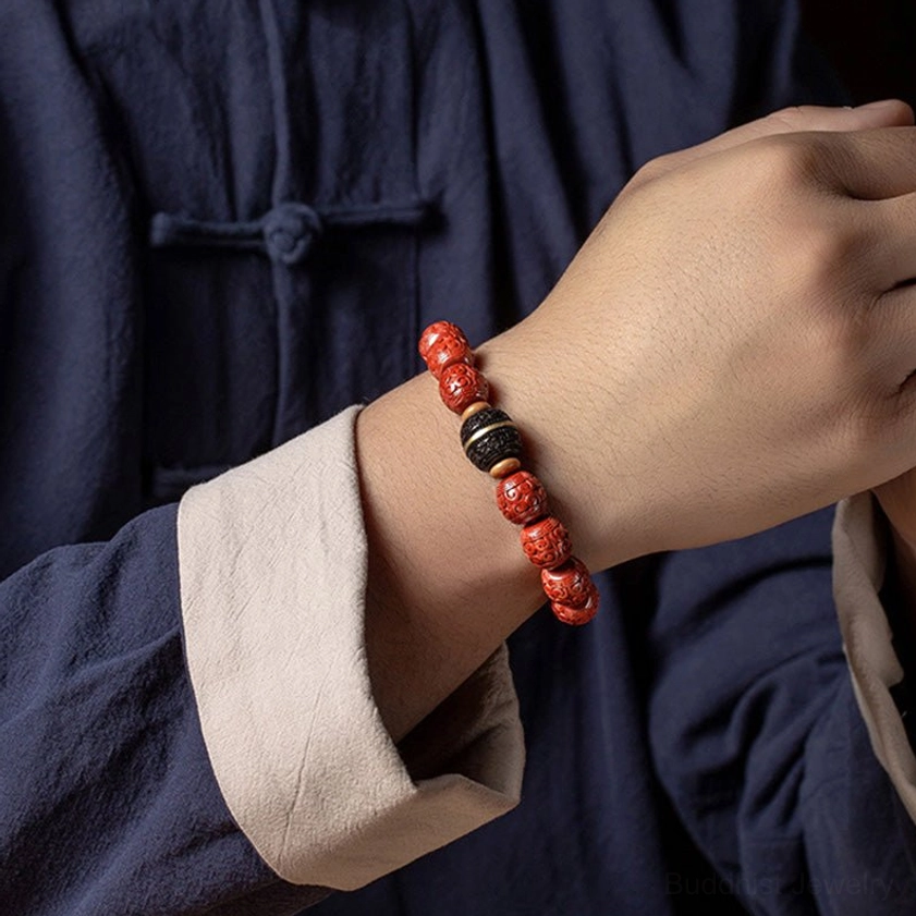 Cinnabar ebony Buddhist blessing bracelet worn on right wrist against traditional Han clothing, side close-up view of bracelet fit and bead details