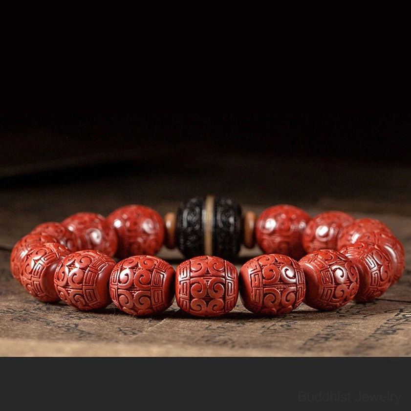 Multiple cinnabar and ebony Buddhist blessing bracelets arranged in side-by-side row on dark tabletop, showing consistent quality and matching design