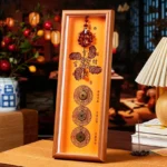 Cinnabar copper coin fortune blessing photo frame ornament with red rosary beads and gold patterns on wooden desktop