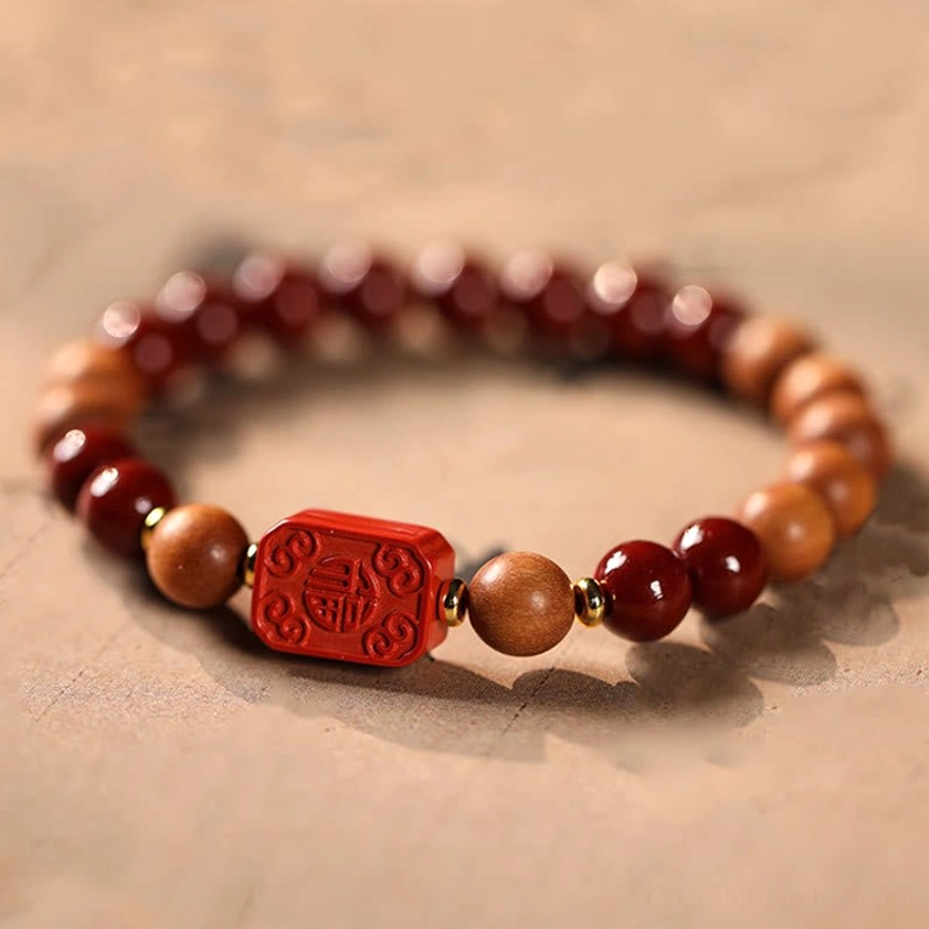 Handmade cinnabar wood bracelet with fu character blessing charm overhead flat lay view