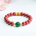 Cinnabar and green agate Om Mani Padme Hum Buddhist blessing bracelet flat lay with red beads and gold mantra bead on white background