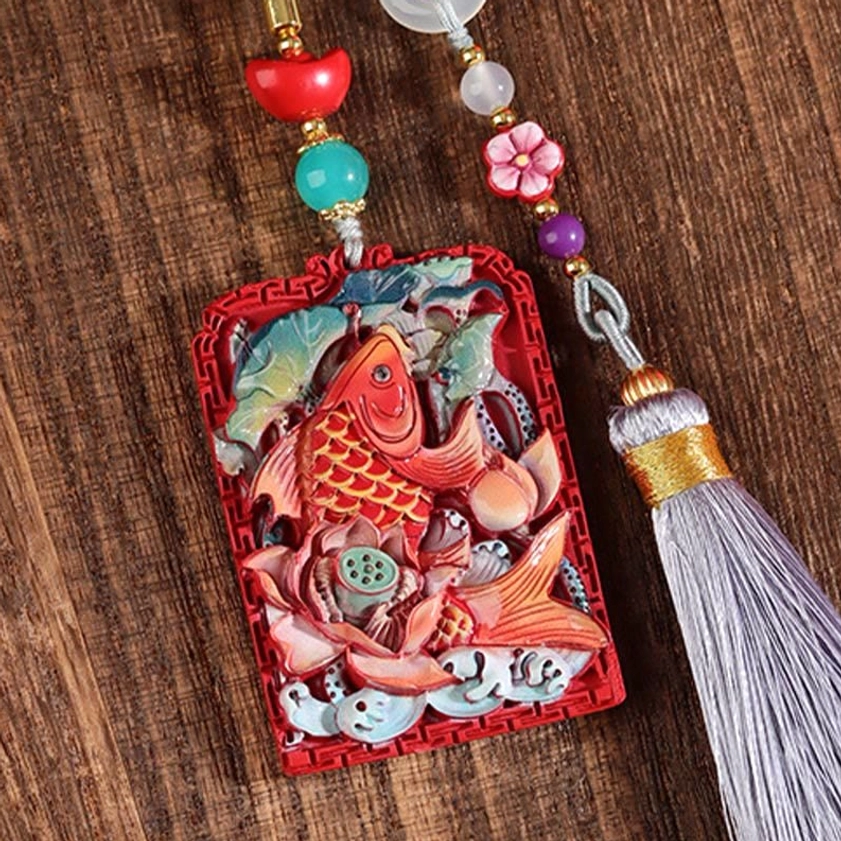 Cinnabar koi lotus car hanging close-up detail showing carved design elements and beaded cord components