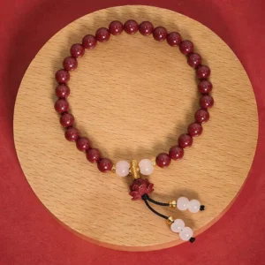 Cinnabar lotus prayer bracelet overhead view with deep red beads and white jade accents on wooden plate, perfect for Buddhist meditation and spiritual practice