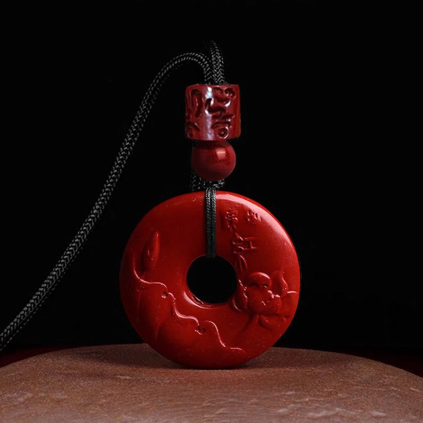 Handcrafted cinnabar peace buckle necklace with engraved lotus relief carving and protective Buddhist symbolism, featuring natural deep red cinnabar material