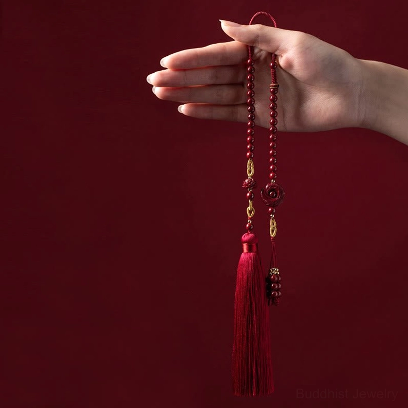 Hand-held display of cinnabar lotus car hanging charm with red beads and silk tassel
