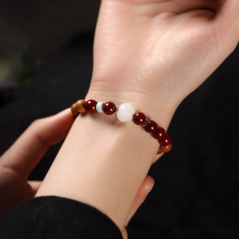 Close-up side view of worn cinnabar lotus fu character bracelet on adult wrist showing actual fit and comfort