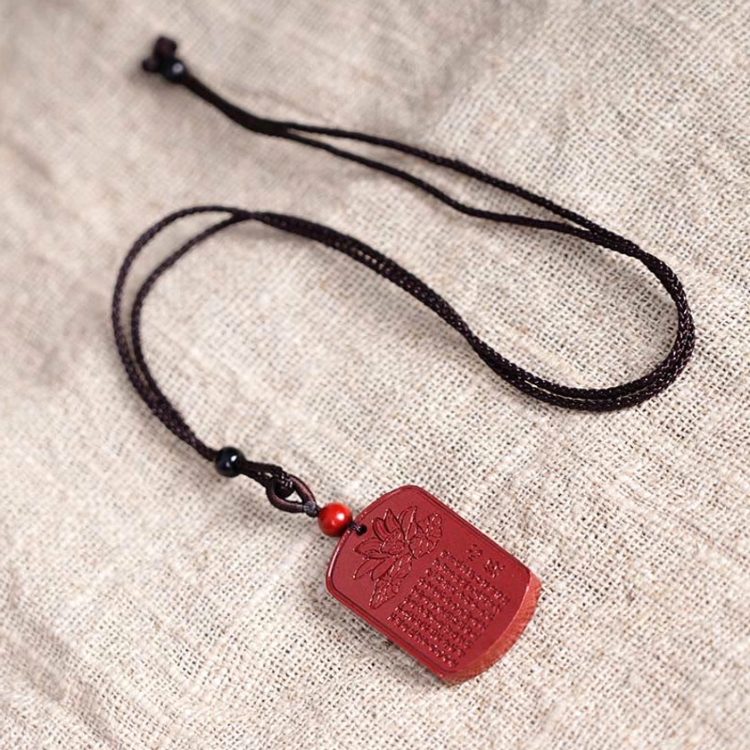 Complete cinnabar lotus heart sutra necklace flat lay showing cord and accent beads