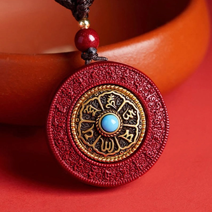 Red cinnabar Buddhist pendant necklace with Om Mani Padme Hum mantra and gold engraved disc, overhead view on terracotta background