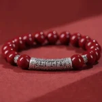 6mm cinnabar and sterling silver Om Mani Padme Hum blessing bracelet flat lay overhead view