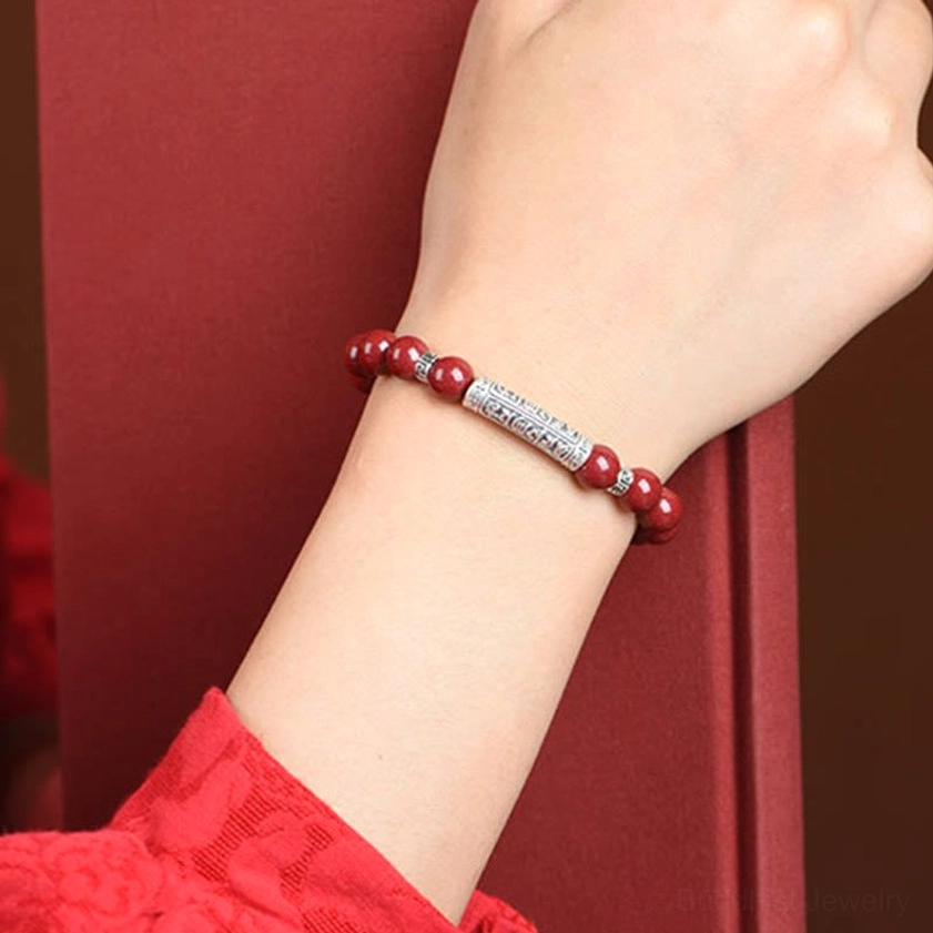Cinnabar and sterling silver Om Mani Padme Hum bracelet worn on wrist showing fit