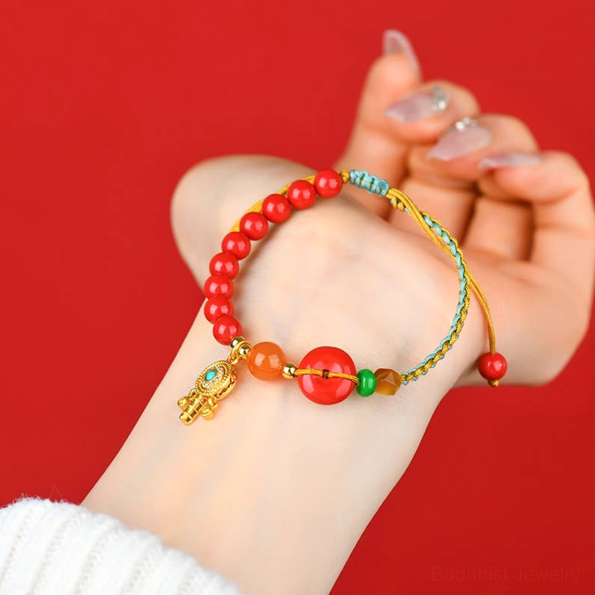 Close-up wrist shot of cinnabar peace buckle Buddhist bracelet, detailed view of pendant beads and braided string