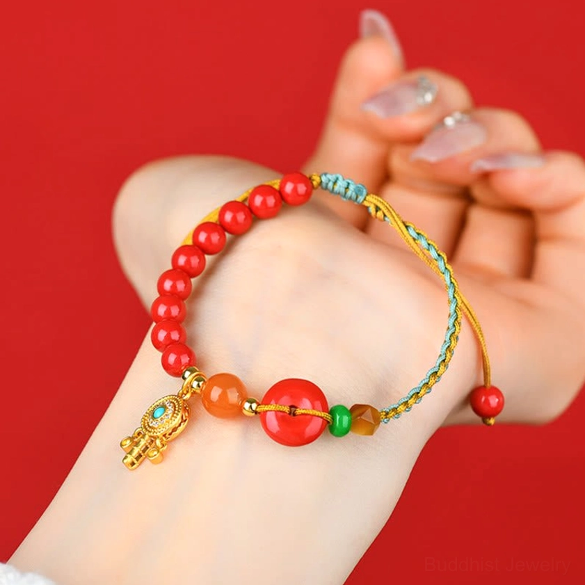 Buddhist red string bracelet with peace buckle worn on wrist, close-up hand-held view showing charm detail