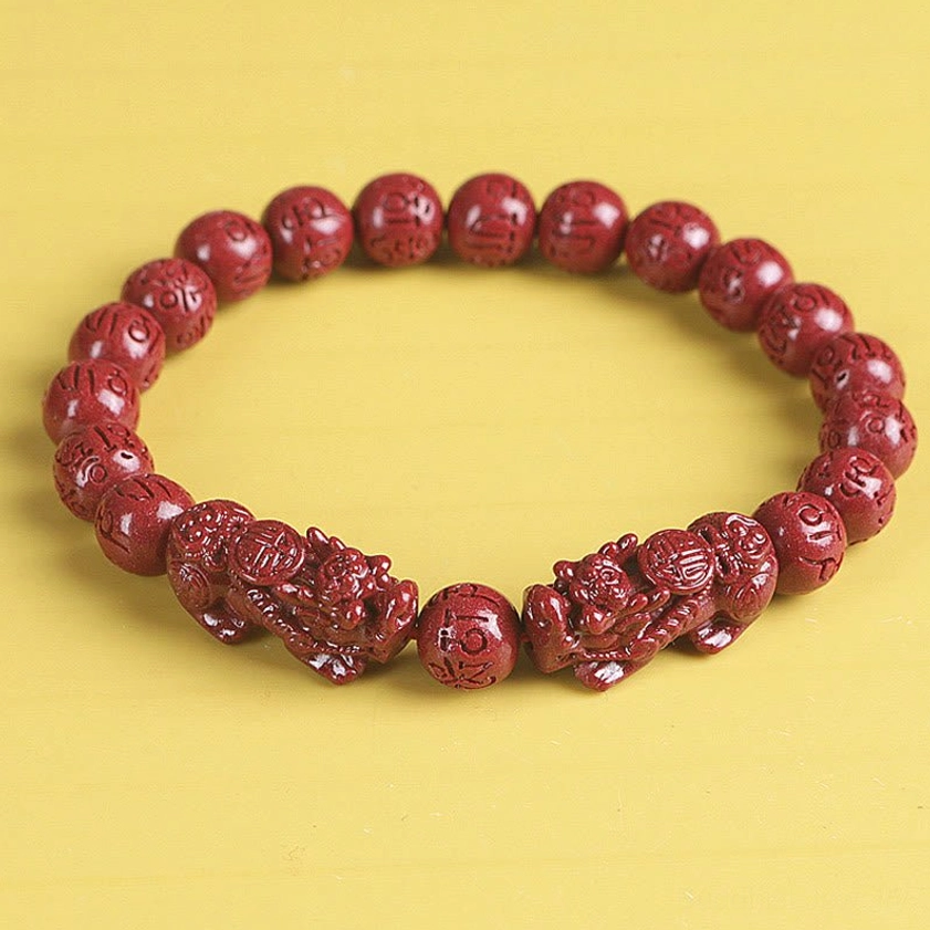 Full view of red cinnabar Pixiu bracelet with carved charms and mantra beads