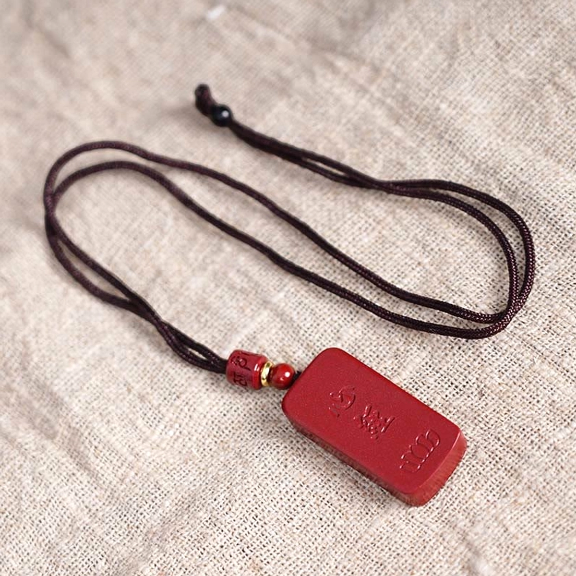 Cinnabar pendant for protection showing natural red stone and sutra text