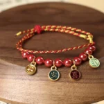 Cinnabar red string blessing bracelet with enamel pendants, artisanal handwoven design for peace and joy